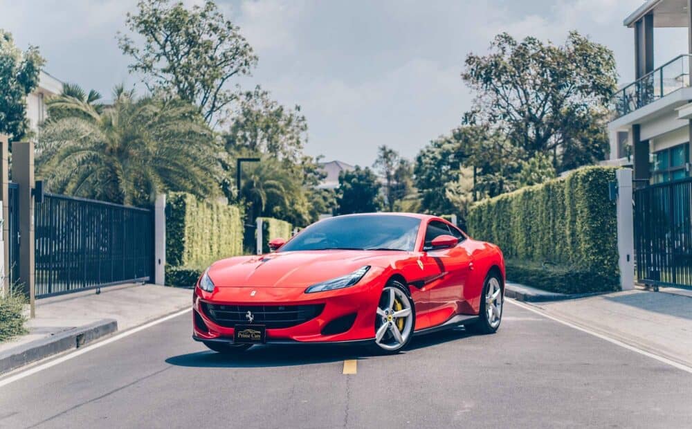 เช่า Ferrari Portofino สีแดง Rosso มุมหน้าเฉียง เต็มคัน บนถนน — ซุปเปอร์คาร์ GT เปิดประทุน V8 600 แรงม้า Prime Cars Rental กรุงเทพ | red Ferrari Portofino front three-quarter on road, V8 GT convertible supercar rental Bangkok Thailand