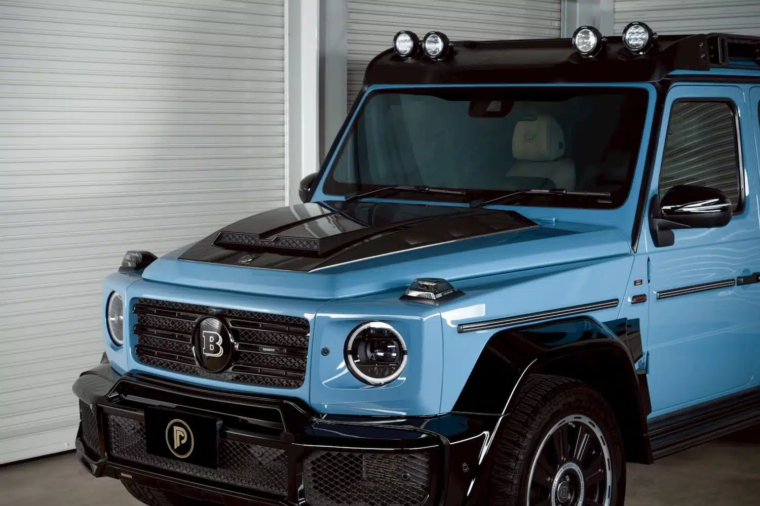 เช่า G Wagon Brabus D40 Adventure สี Vintage Blue มุมหน้าซ้าย roof rack สปอตไลต์ กระจัง Brabus — Mercedes G400d ออฟโรดหรูหายาก Prime Cars Rental Bangkok | Brabus D40 Adventure G-Wagon Vintage Blue front three-quarter roof rack spotlights, rare Mercedes G-Class rental Thailand