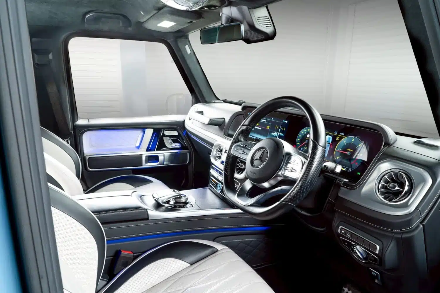 ห้องโดยสาร G Wagon Brabus D40 หนัง designo สีขาว จอคู่ widescreen พวงมาลัยขวา ไฟ ambient น้ำเงิน — เช่ารถหรู Prime Cars Rental | Brabus G-Wagon cockpit white designo leather dual widescreen RHD blue ambient