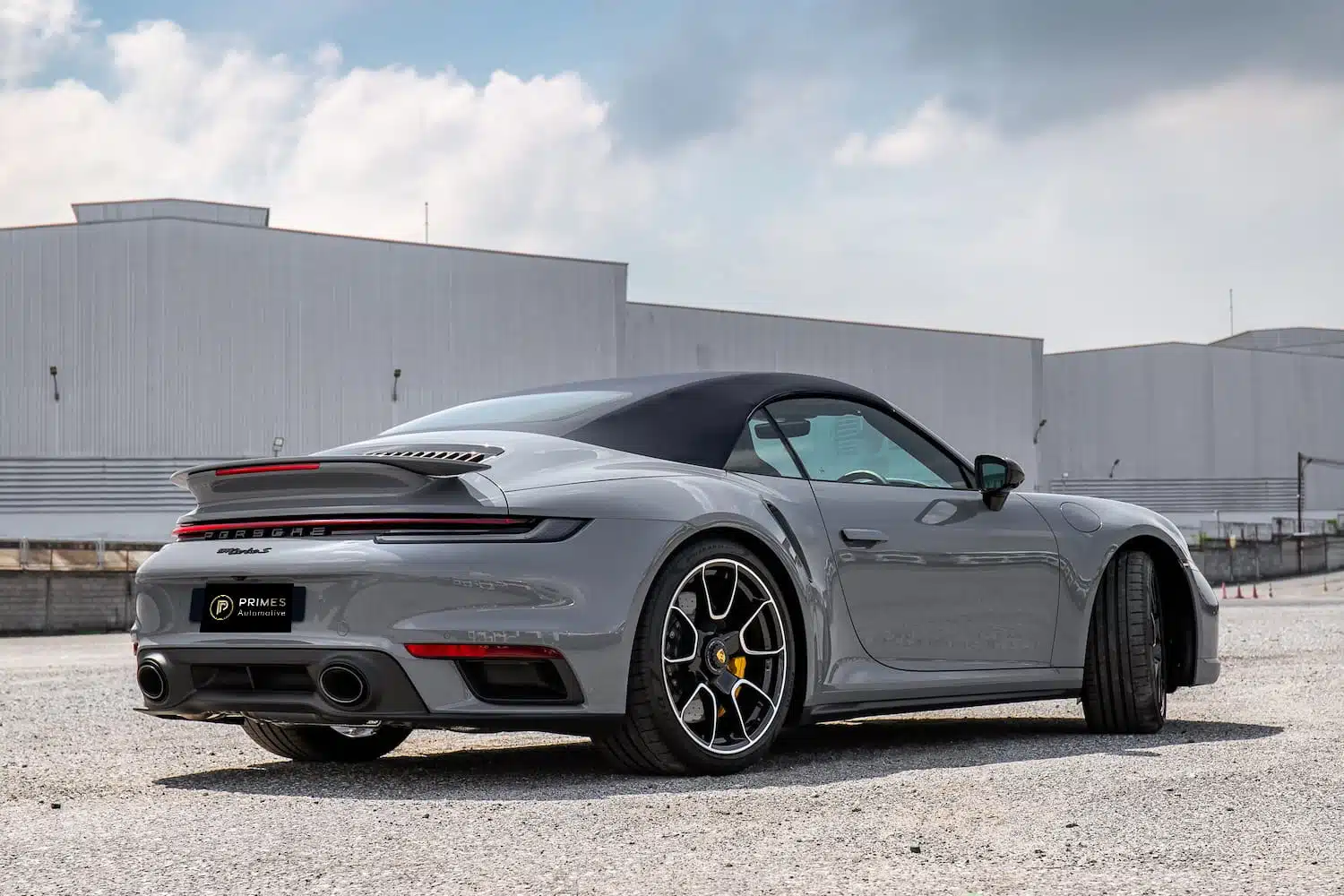 Porsche 911 Turbo S Cabriolet 992 มุมหลังขวา สปอยเลอร์ยกขึ้น เบรก Carbon Ceramic คาลิปเปอร์เหลือง — เช่ารถหรู Prime Cars Rental | Porsche 911 Turbo S Cabriolet rear three-quarter active spoiler PCCB yellow calipers, luxury car rental Bangkok